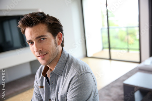 Portrait of 30-year-old man sitting in living-room
