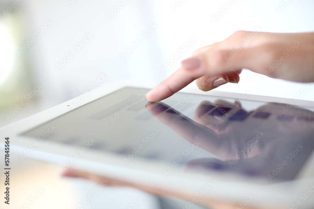 Closeup of hand sliding on digital tablet - obrazy, fototapety, plakaty 