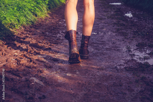 Young woman walking along muddy trail