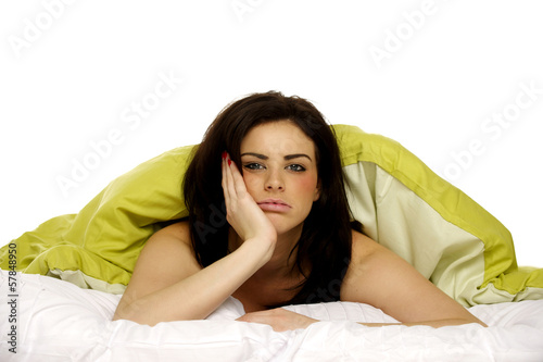 Beautiful woman in bed under a green duvet