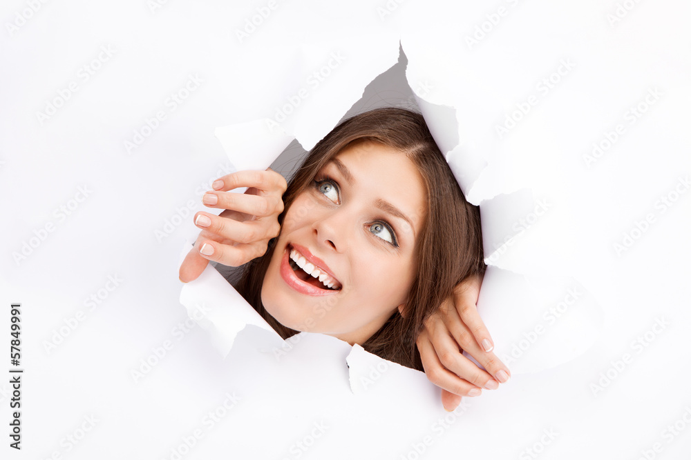 Young woman breaking through a paper sheet Young woman breaking through a paper sheet