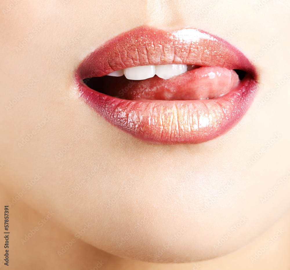 Fototapeta Woman licks her lips with tongue