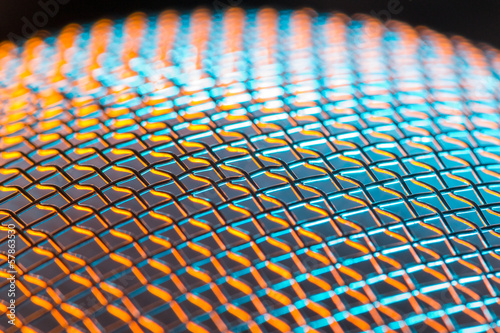 Steel net sphere lit in blue and orange. Shallow depth of field photo