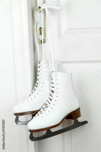 Figure skates hanging on a door knob