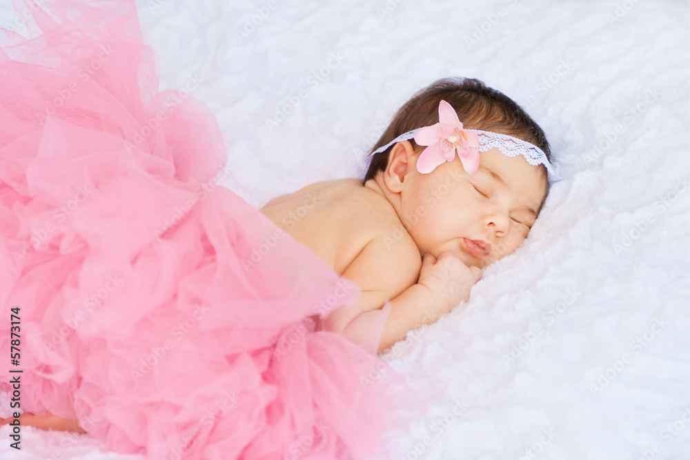 Little girl in a pink skirt is sleeping on the stomach Little girl in a pink skirt is sleeping on the stomach