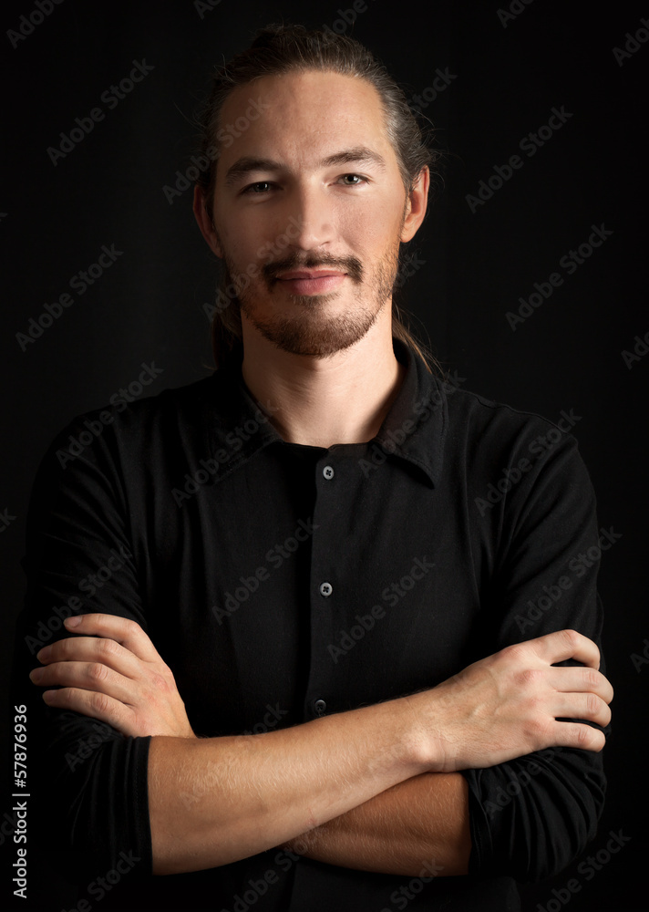 Young smart Oriental man on black background