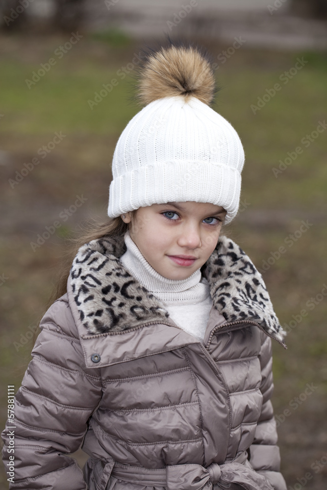 Little girl in a white knitted hat autumn Little girl in a white knitted hat autumn