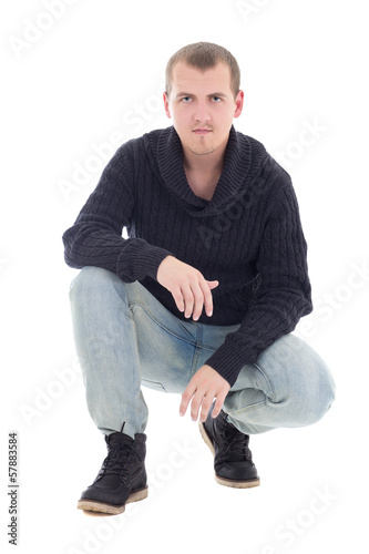 young attractive man in winter clothes sitting isolated on white © Di Studio