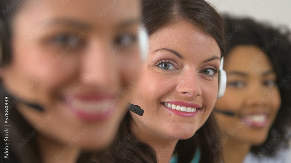 Rack focus between three customer service representatives smilin Rack focus between three customer service representatives smilin