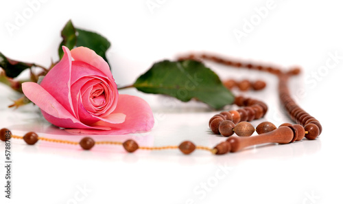 Muslim rosary and pink rose on a white background photo