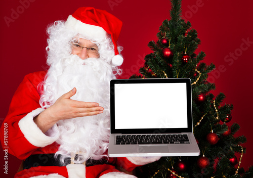 Portrait of a happy santa holding laptop