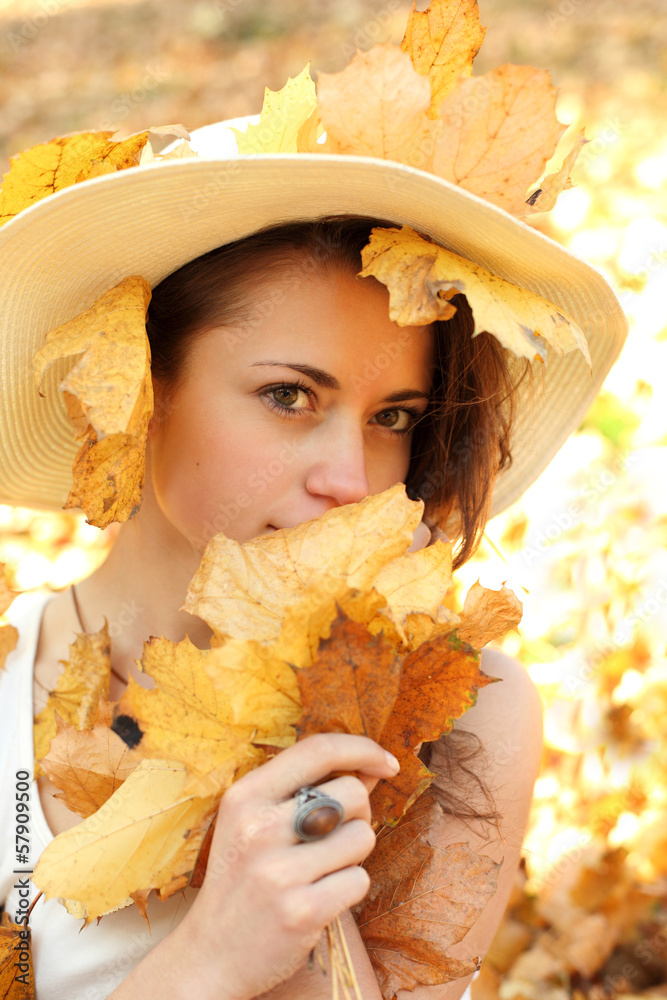 Piękna dziewczyna w kapeluszu i jesienne liście. - obrazy, fototapety, plakaty 