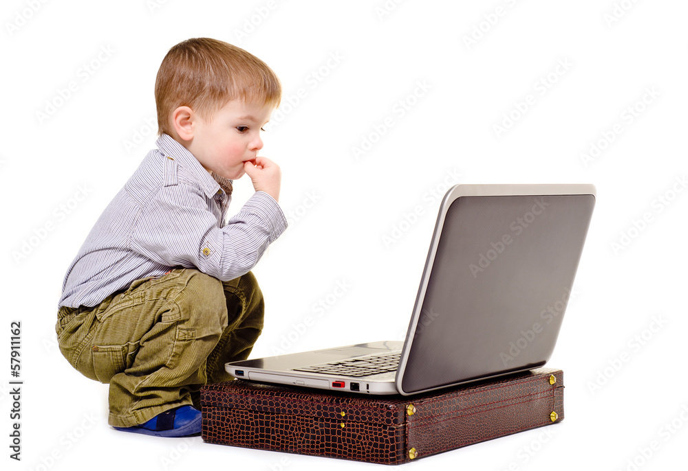 Little boy thoughtfully sits at a notebook Little boy thoughtfully sits at a notebook
