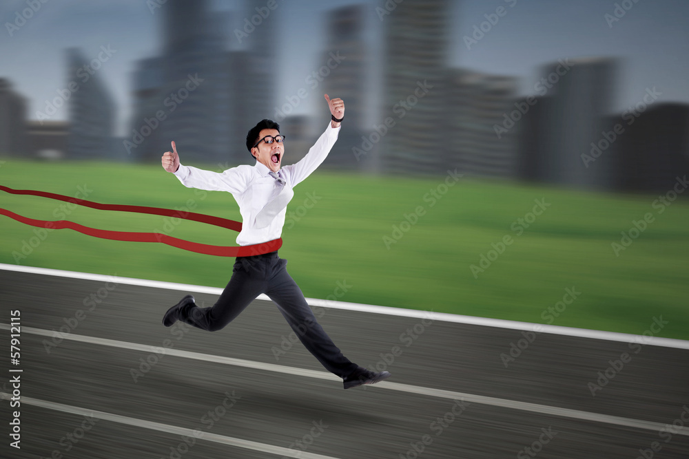 Asian businessman crossing the finish line