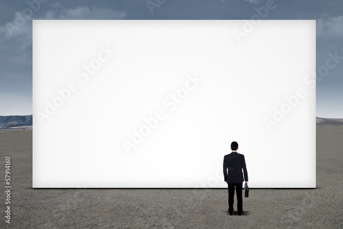 Businessman looking empty billboard © Creativa Images