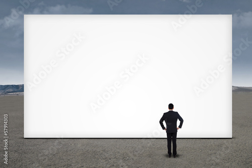 Businessman standing in front of empty board