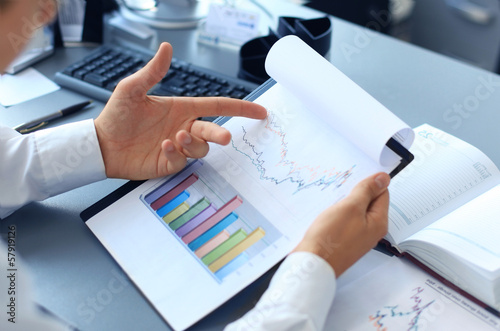 Close-up of graphs and charts analyzed by businessman