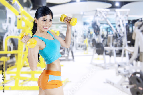 Happy fitness woman with dumbbells