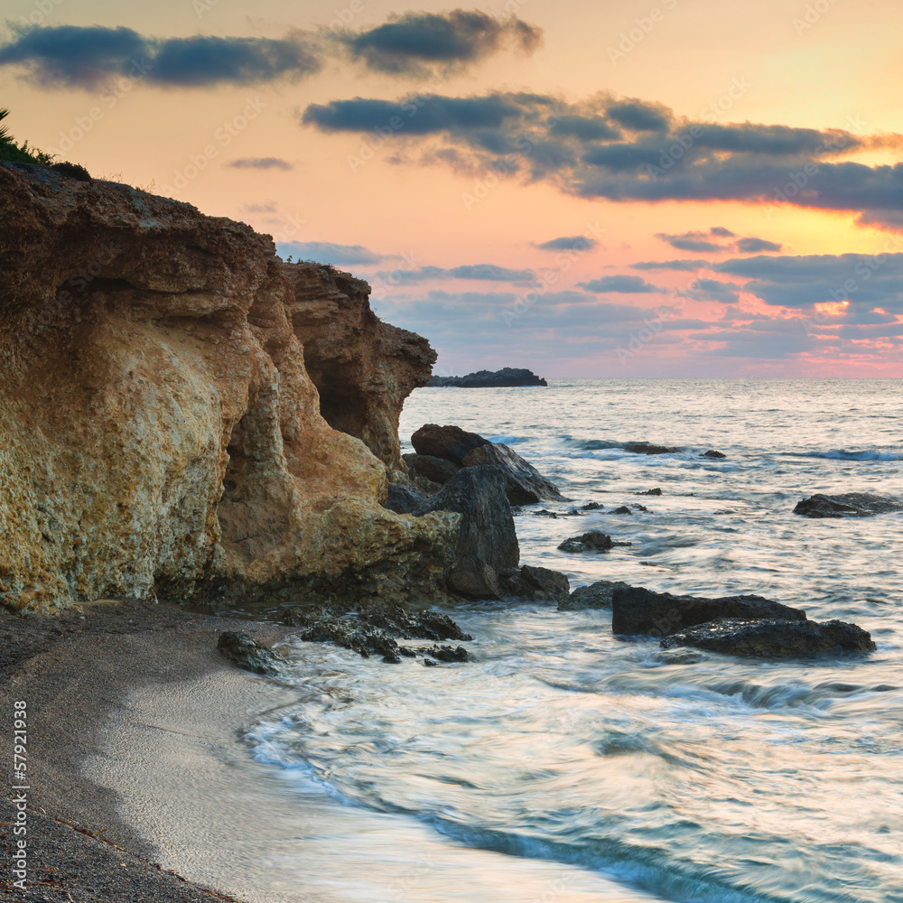 Stunning landscape dawn sunrise with rocky coastline