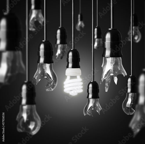idea concept with broken bulbs and one glowing energy saving bul photo