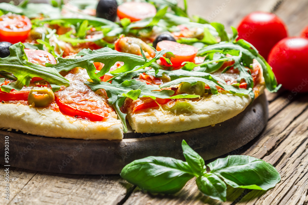 Closeup of freshly baked pizza with basil and tomatoes Closeup of freshly baked pizza with basil and tomatoes