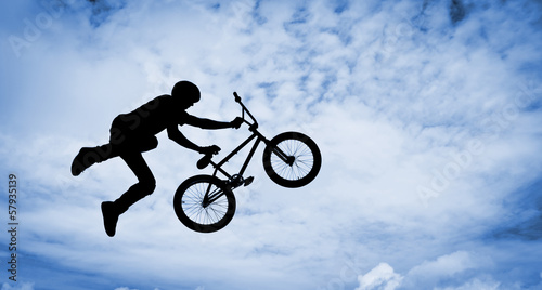 Fotografering Silhouette of a man doing an jump with a bmx bike.