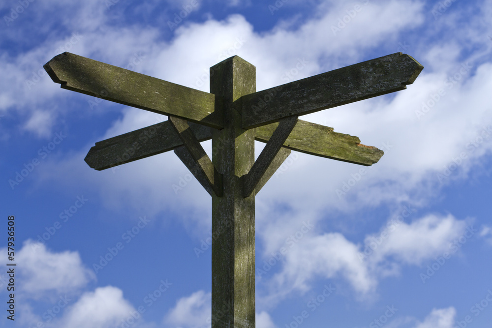 Old Blank Wooden Signpost against a Cloudy Blue Sky Background