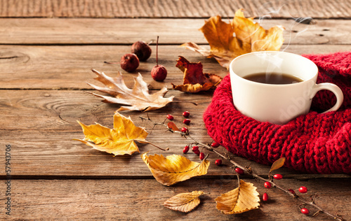 Hot coffee and autumn leaves on vintage wood background © pinkyone