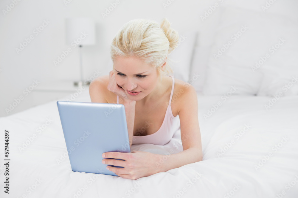Serious casual blond using tablet PC in bed Serious casual blond using tablet PC in bed