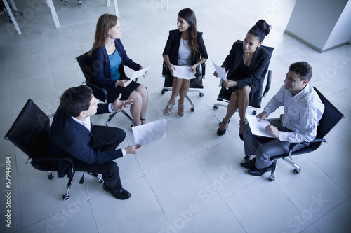 Business people sitting in a circle having a business meeting