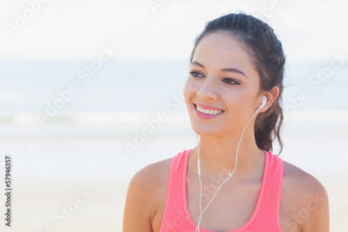 Smiling healthy woman with earphones on beach © WavebreakmediaMicro