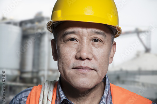 Portrait of proud worker in protective workwear outside of a factory
