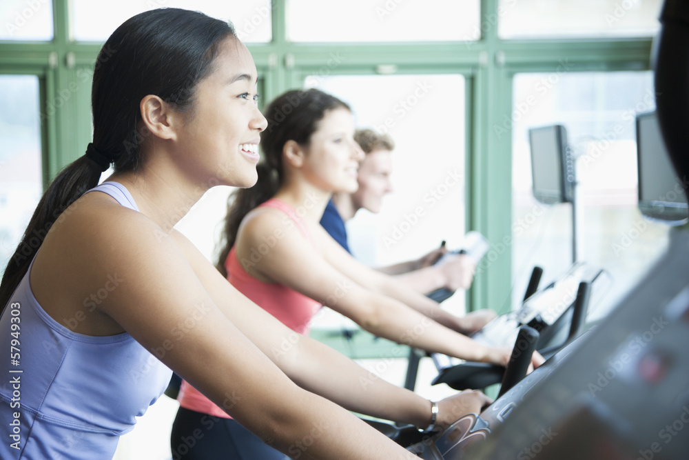 Young women exercising on fitness bikes in the gym 