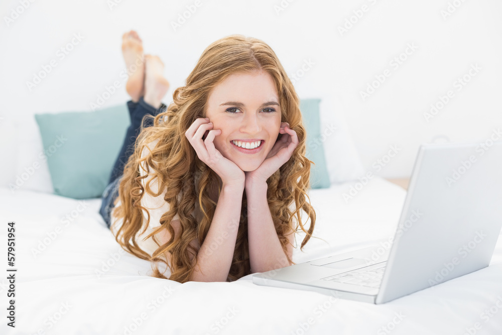 Portrait of smiling casual blond using laptop in bed Portrait of smiling casual blond using laptop in bed