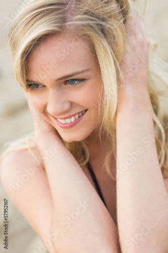 Smiling relaxed young blond looking away at beach
