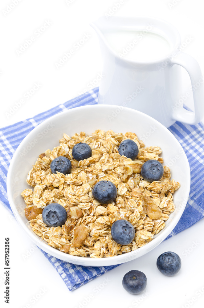 muesli with blueberries and jug of milk isolated on white muesli with blueberries and jug of milk isolated on white