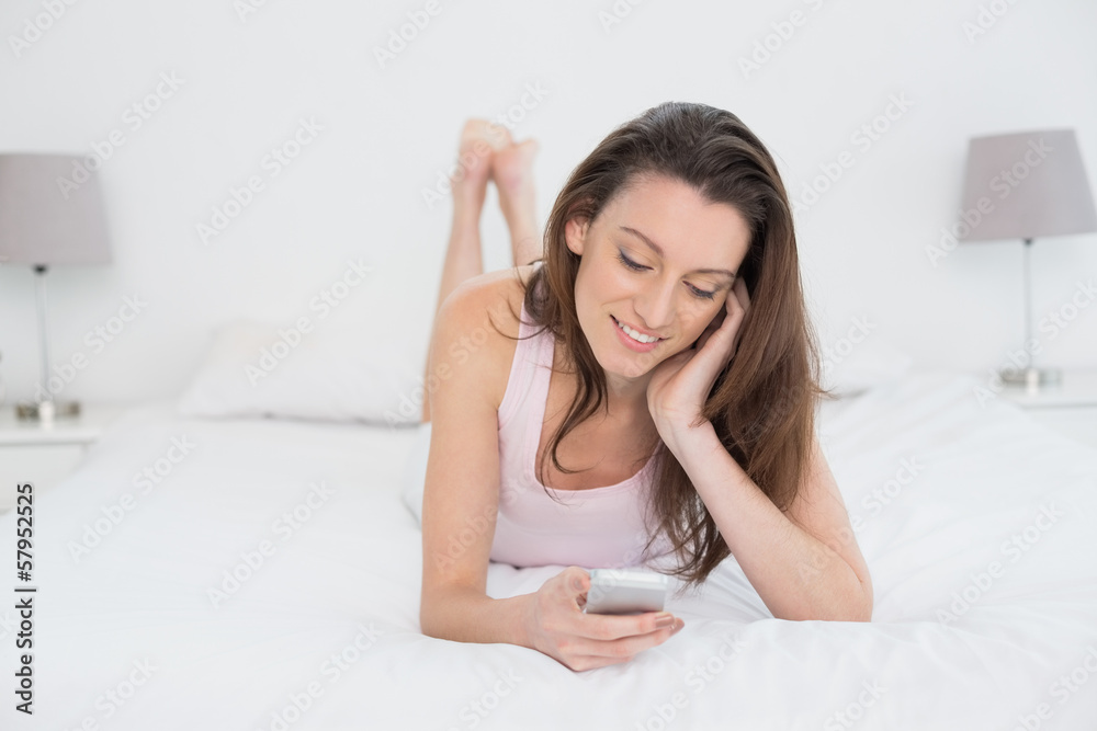 Relaxed happy woman looking at mobile phone in bed Relaxed happy woman looking at mobile phone in bed
