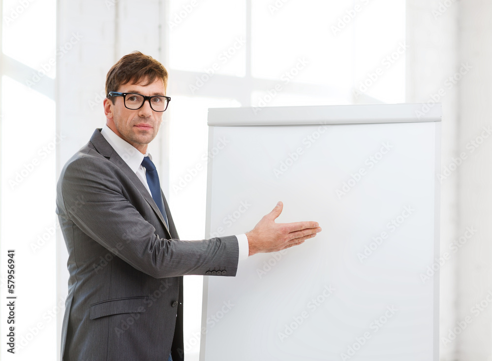 businessman pointing to flip board in office businessman pointing to flip board in office