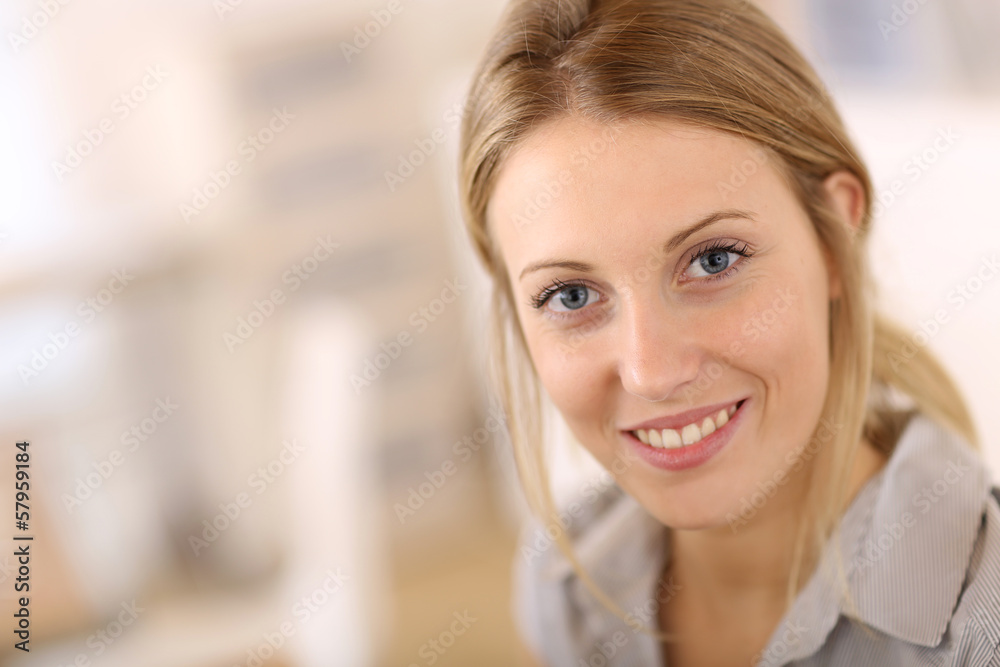 Portrait of beautiful office-worker sitting at desk