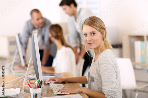Canvas Print Young girl in office working on desktop computer