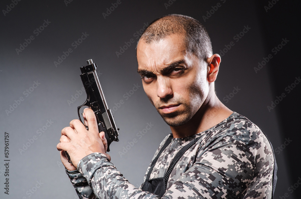 Soldier with guns against dark background Soldier with guns against dark background