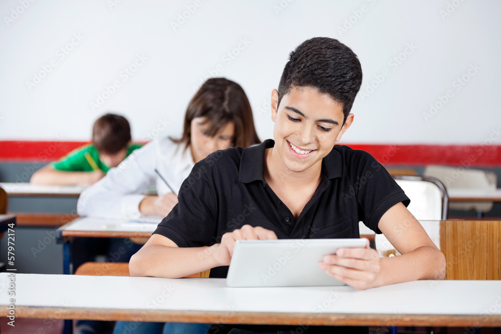 Teenage Schoolboy Using Digital Tablet At Desk Teenage Schoolboy Using Digital Tablet At Desk