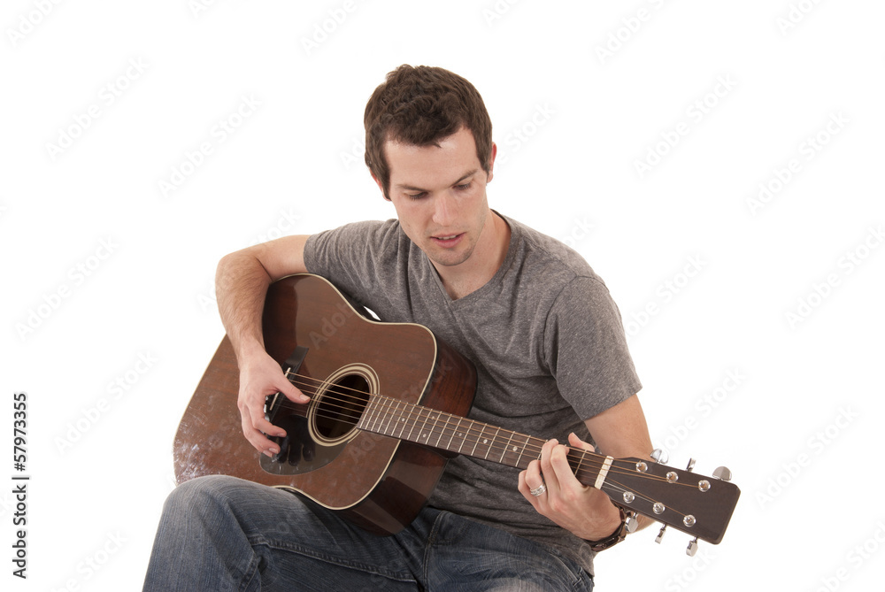 Young man playing acoustic guitar sitting Young man playing acoustic guitar sitting