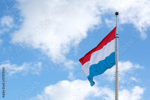 Canvas Print Luxembourg flag is waving in front of blue sky and puffy clouds