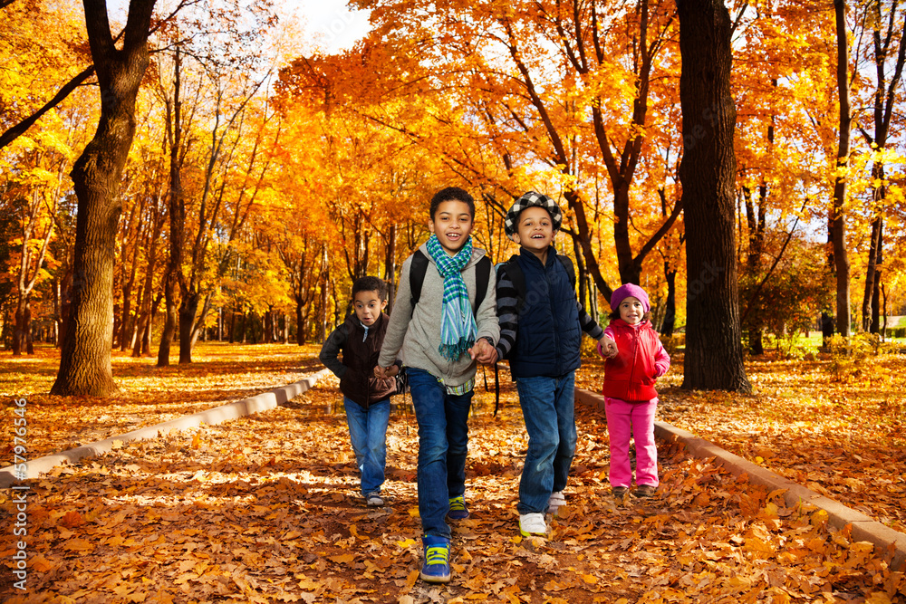 Group of kids go to school in autumn park Group of kids go to school in autumn park