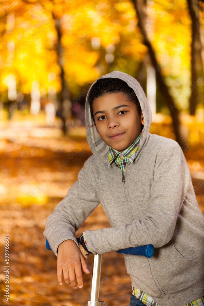 Boy with scooter in autumn park Boy with scooter in autumn park