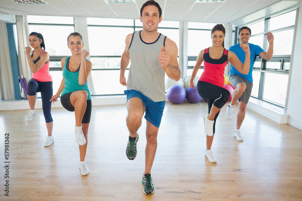 Obraz premium Full length of fitness class and instructor doing pilates exerci