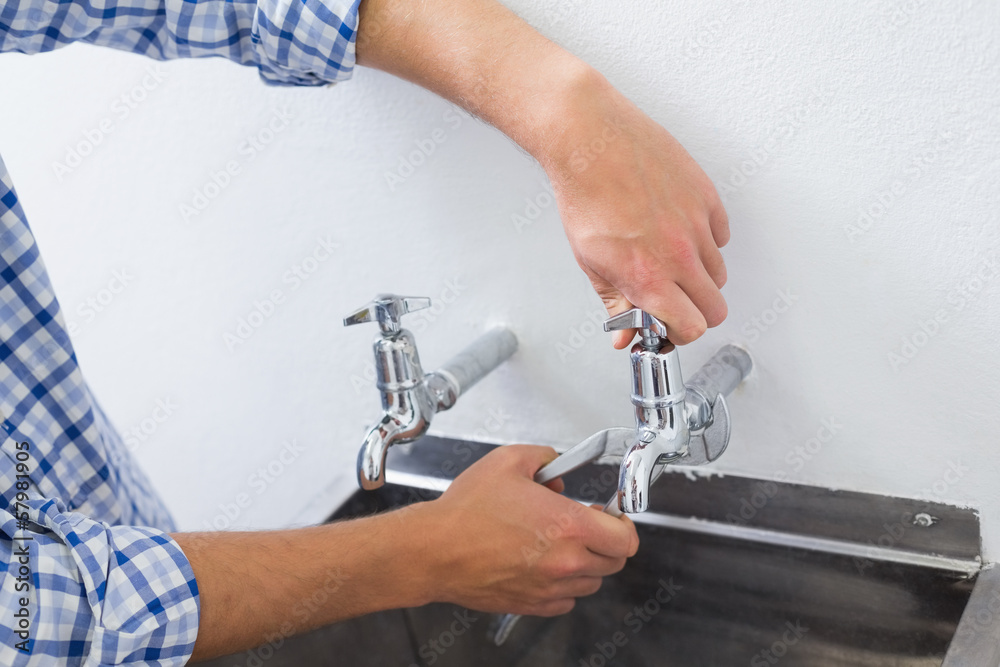 Close up of a plumber's hand and washbasin Close up of a plumber's hand and washbasin