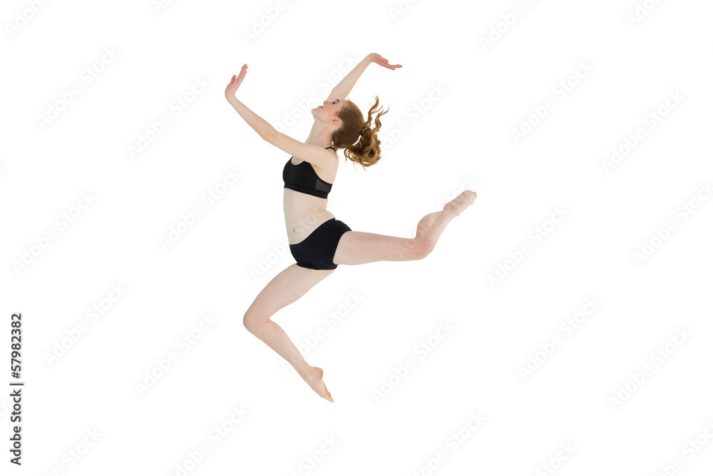 Side view of a sporty young woman jumping