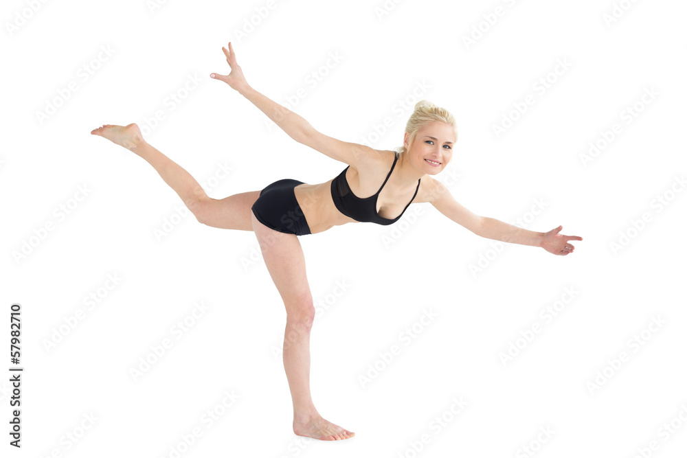 Sporty young woman balancing on one leg